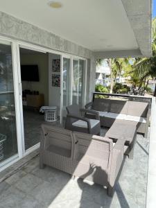 a patio with couches and chairs and a television at Hermosos Apartamentos Frente Al Mar in San Andrés