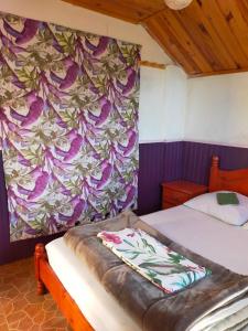 a bedroom with a bed with a floral wall at KER L'ÎLET in Cilaos