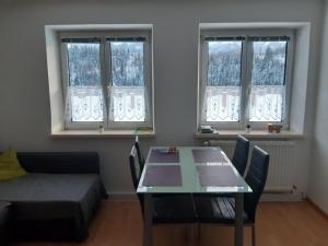a living room with a table and two windows at Four Seasons Apartment Josef in Eisenerz