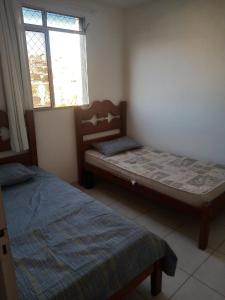 - une chambre avec 2 lits et une fenêtre dans l'établissement Condomínio encantador com estacionamento, à Vespasiano