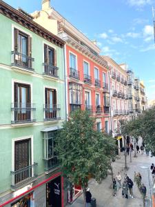 een groep mensen die door een straat met gebouwen lopen bij Apartamentos Fuencarral II in Madrid