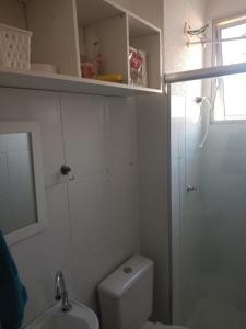 a white bathroom with a toilet and a sink at Condomínio encantador com estacionamento in Vespasiano