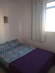 a bed in a room with a window and a bed sidx sidx sidx at Condomínio encantador com estacionamento in Vespasiano