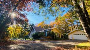 a house with a driveway in the fall at 1 Minute to Pool & Beach, Spacious Getaway, AC, Hot tub, Game room in Pocono Country Place