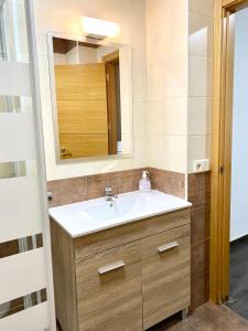 een badkamer met een wastafel en een spiegel bij Apartamentos Fuencarral II in Madrid