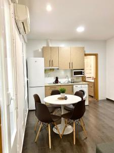 een keuken met een tafel en stoelen in een kamer bij Apartamentos Fuencarral II in Madrid