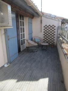 a porch with a bench and a table on it at Joli/calme et spacieux appartement. in Tarascon