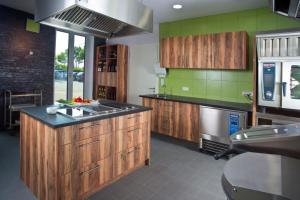 a kitchen with wooden cabinets and a sink at Rotenberg PT Hotel in Wittlich