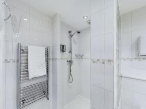 ein weißes Bad mit einer Dusche und einem Spiegel in der Unterkunft The Beach House, Luxury Apartments in Blackpool