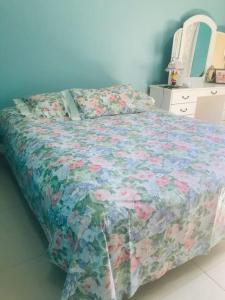 1 dormitorio con 1 cama con colcha de flores en Casa Bignonia Amplio y confortable Ideal para familias con niños y mascotas, en Ciudad del Este