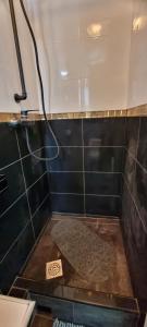 y baño con ducha y suelo de baldosa. en Sympa Appartement avec 2 chambres séparées, en Persan