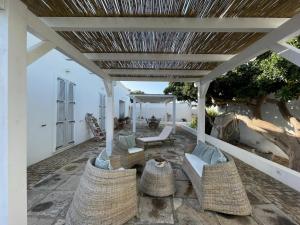 a patio with wicker chairs and a pergola at Dimora Ferralasco in Carloforte
