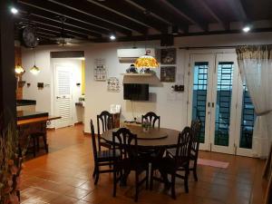 eine Küche und ein Esszimmer mit einem Tisch und Stühlen in der Unterkunft Harmonia Homestay in Malakka