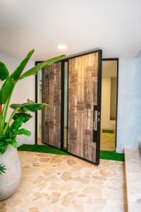 una puerta de cristal abierta en una habitación con una planta en Villa La Gema, en Medellín
