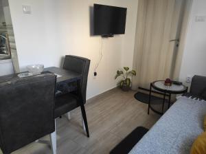 een woonkamer met een bureau en een tafel met een stoel bij Andrea Airport Apartments in Belgrado