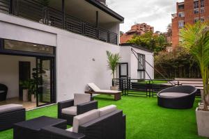 d'une terrasse meublée avec de la pelouse verte dans un bâtiment. dans l'établissement Villa La Gema, à Medellín