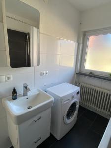 a bathroom with a washing machine and a sink at Nisas Ferienwohnung in Bad Säckingen