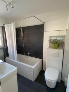 ein Badezimmer mit einer Badewanne, einem WC und einem Waschbecken in der Unterkunft Nisas Ferienwohnung in Bad Säckingen
