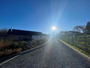 een zon schijnt op een weg met een hek bij Elm Cottage in Tenby