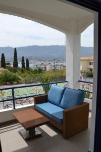 a blue couch on a balcony with a view at Valente Perlia Rooms in Poros