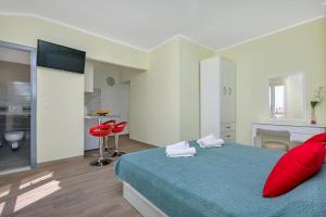 una camera con letto blu e cuscini rossi di Villa NIKA & KARLO Makarska a Makarska