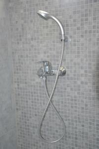 a shower with a shower head in a bathroom at Valente Perlia Rooms in Poros