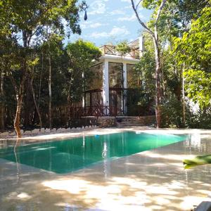 a house with a swimming pool in front of a house at Saasil Kaax in Chemuyil