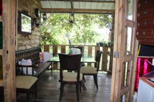 a dining room with a table and chairs on a porch at Lomaroja ecohabs in Palmira