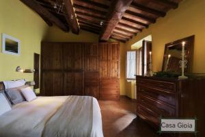 a bedroom with a large bed and a dresser at PienzaLettings "Casa Gioia" in Pienza
