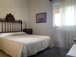 Un dormitorio con una cama grande y una ventana en Jardin de la Yedra, en Cáceres