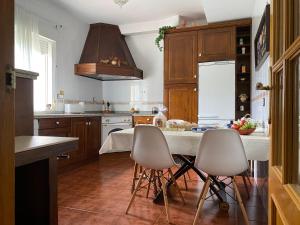 a kitchen with wooden cabinets and a table with chairs at Jardin de la Yedra in Cáceres