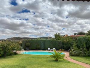 a swimming pool in a yard with a hedge at Jardin de la Yedra in Cáceres