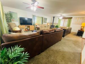 sala de estar con sofá marrón y TV en Family friendly, 3 bedroom house, with king bed for up to 15 - BBQ - Internet - jet tub, en Auburn