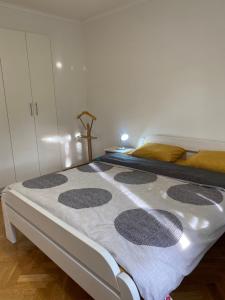 1 dormitorio con 1 cama con manta blanca y gris en NaPjacu with own parking and garden, en Herceg-Novi