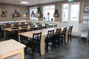 a dining room with tables and chairs and pendant lights at Hafnarstræti Hostel in Akureyri