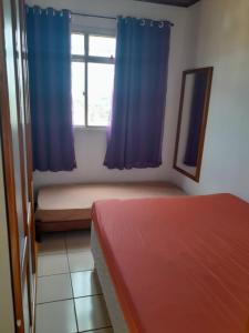 sypialnia z 2 łóżkami i oknem z niebieskimi zasłonami w obiekcie Apartamento com vista para o mar em Setiba Guarapari w mieście Guarapari