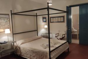1 dormitorio con cama con dosel y mesa en Villa del glicine, en Muro Leccese