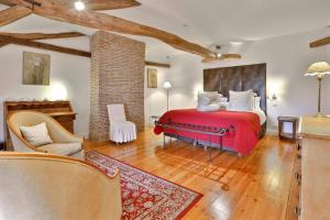 een slaapkamer met een rood bed in een kamer bij La Chartreuse du Bignac - Teritoria in Saint-Nexans