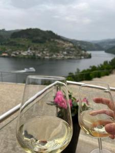 two glasses of white wine sitting on a table at Casa das Oliveiras, o Douro no seu esplendor! in Cinfães