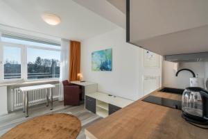 a kitchen with a table and a desk in a room at Huber Living Single 201 in Germering