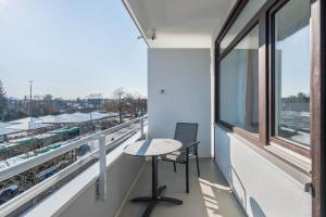 a table and chair on a balcony with a view at Huber Living Single 201 in Germering