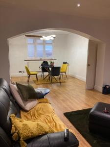 sala de estar con sofá y mesa con sillas en Green Villa en Hickleton