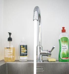 un fregadero con un grifo y dos botellas de jabón en NSD Home en Amberes