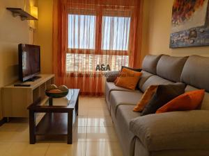 a living room with a couch and a tv at Apartamento En Mediterráneo Real, Los Boliches, Fuengirola in Fuengirola