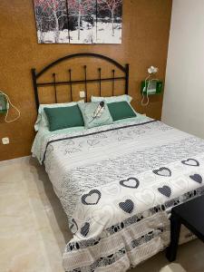 a bedroom with a large bed with green and white sheets at Alojamiento Rural Samburiel in Becerril de la Sierra
