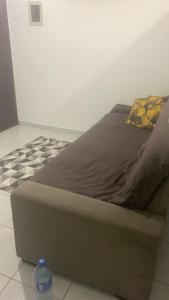 Bett in einem Zimmer mit einer Flasche auf dem Boden in der Unterkunft Apto confortável in Solemar