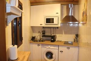 a kitchen with a washing machine and a microwave at Apartamentos Homelife Coliseo in Toledo