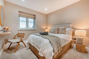 een slaapkamer met een bed, een stoel en een raam bij Riverview in Burford