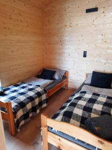 a room with two beds in a log cabin at Wiatr i Woda Wdzydze in Wdzydze Kiszewskie