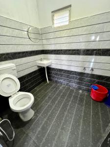 a bathroom with a toilet and a sink at Hiddenvalley Stays - Nethra in Madikeri